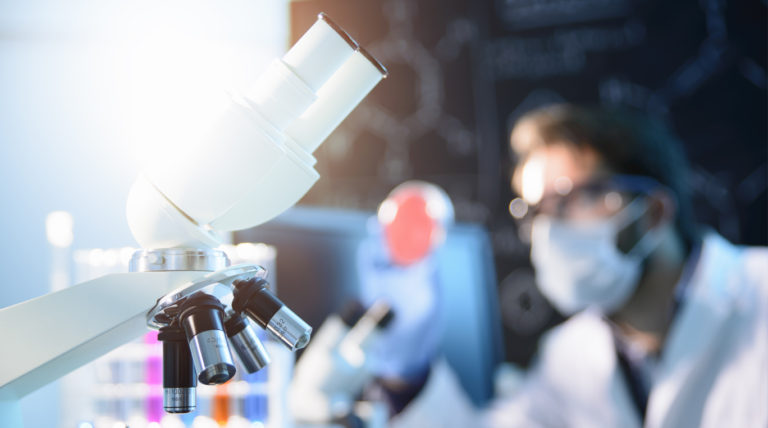 photograph of a microscope and scientists