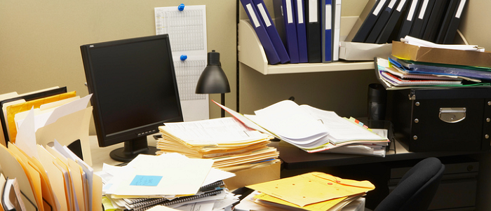 piles of papers around a computer