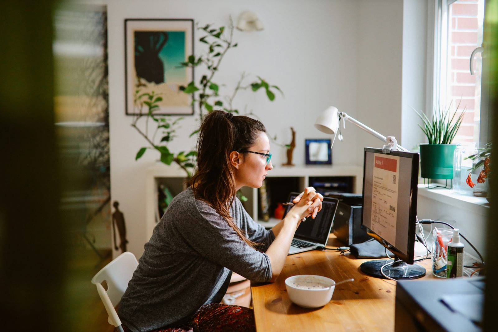 woman at a desk in front of a computer at home